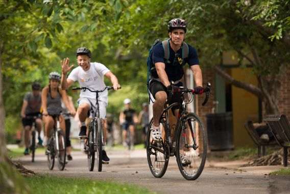 Cyclists travel on the trail through Ruby McQuain Park