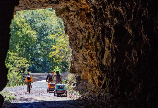 Cyclists ride through the Greenbrier Trail tunnel