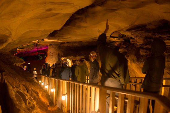 A group walks along a lighted area of Laurel Caverns