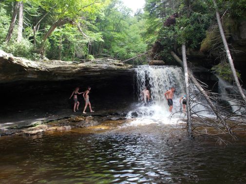 A group plays around underneath a Red Creek water fall