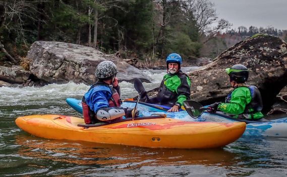 Three kayakers gather at the bottom of a rapid on the Middle Meadow River