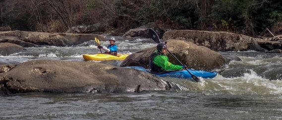 Two kayakers paddle through a rapid on the Upper Meadow River