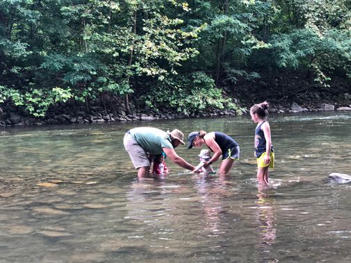 A young family playing in the creek