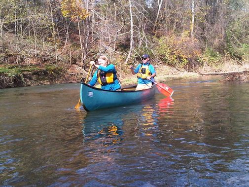 A couple maneuvers their canoe along Dunkard Creek