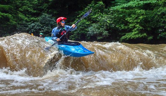 A kayaker does a small boof on the Little Sandy Creek