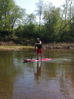 A person on a SUP paddles on Middle Island Creek