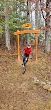 A mountain biker rides through the entrance gate at Upshur County Trails