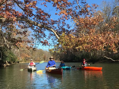 A canoe and kayaks take a break on a fall day trip on the Big Sandy Creek