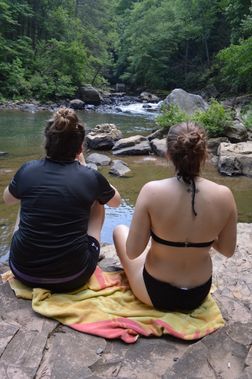 Two people sitting along the creek at Blue Hole