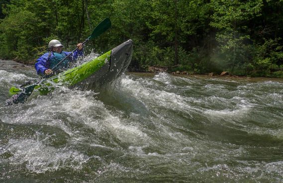 A person in an inflatable kayak launches over a big wave on the North Branch