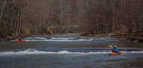 Kayakers paddle through a ledge rapid on the Elk River