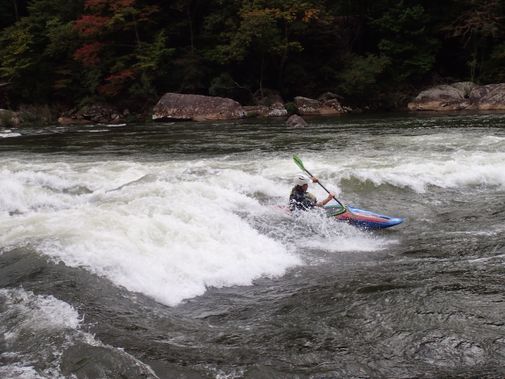 A kayaker surfs a hole on the Lower Gauley River