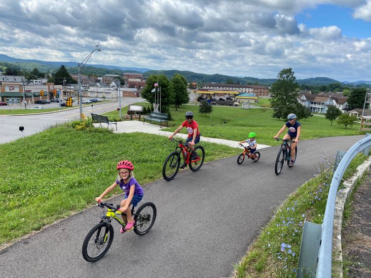 A family rides bikes in Elkins on the Allegheny Highlands Trail