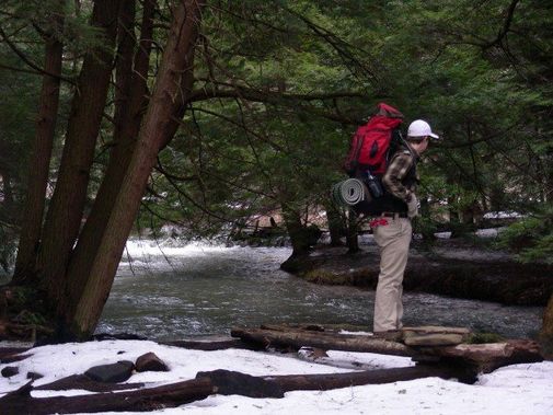 A backpacker surveying a stream 