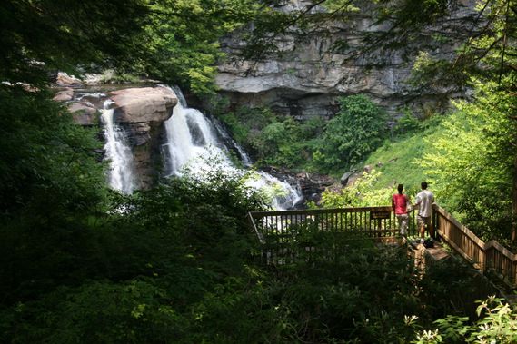 Two people look at Blackwater Falls from the viewing platform