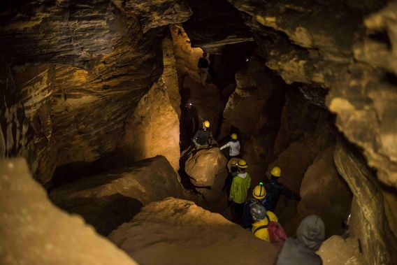 A group walks single file in Laurel Caverns