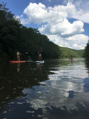 People paddle SUP's on Tygart Lake