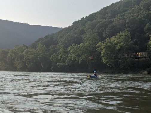 A kayaker paddles down a calm section of the New River