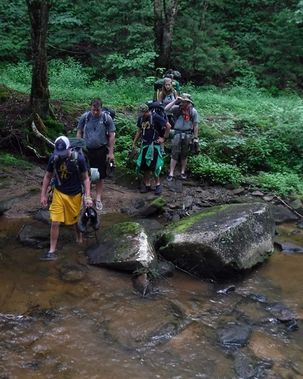 Backpackers cross a stream in Tea Creek Backcountry