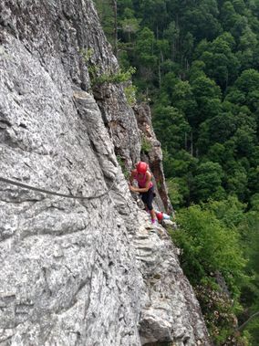 A person climbing up the Via Ferrata