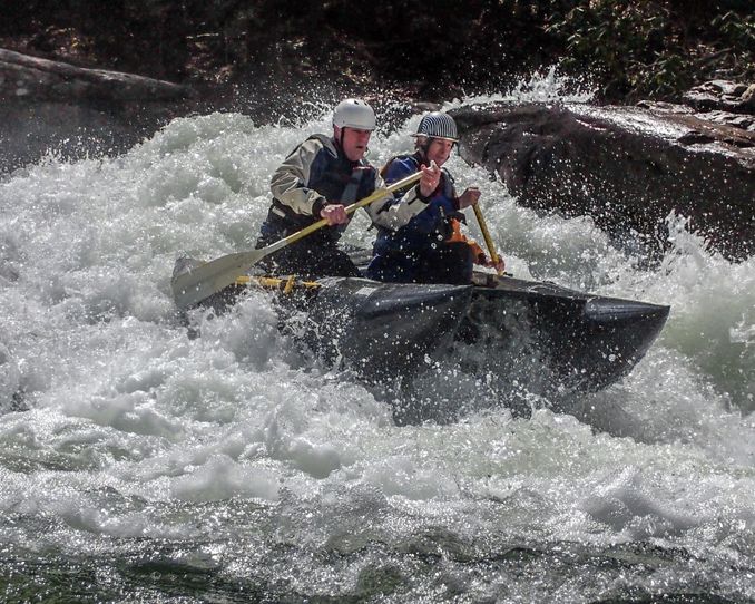 Two people on a Shredder paddle through a rapid on the Tygart Gorge