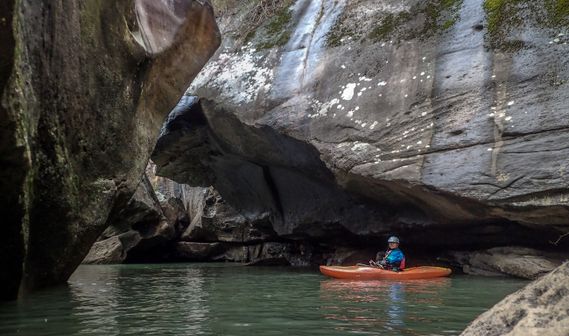 A kayaker paddles under huge boulders on the New River Dries
