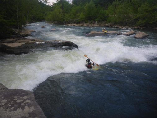 A kayaker paddles hard through a hole on the Tygart Gorge