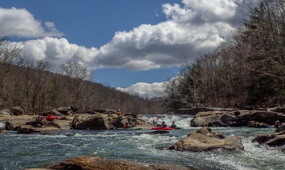 A group of whitewater paddlers below a rapid on the Tygart River Gorge