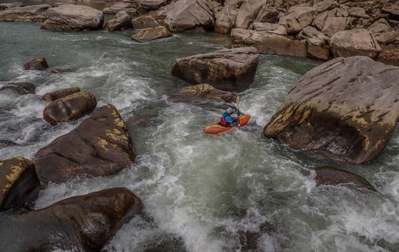 A kayaker paddles through a boulder garden on the New River Dries
