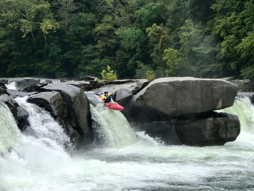 A kayaker launches off of Valley Falls