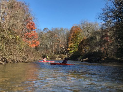 kayaks paddle upstream on a small rapid