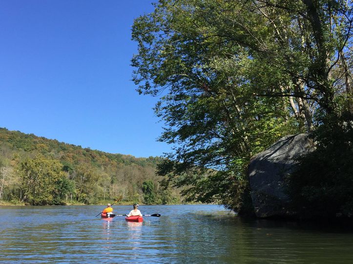 Kayakers paddle around "Jump Rock" on the Mon. 