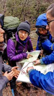 A group of backpackers checks their map