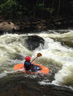 A younger kayaker going down the main drop in Calamity Rapid