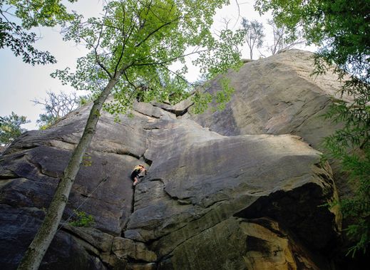 A climber working their way up the rock at the New River Gorge